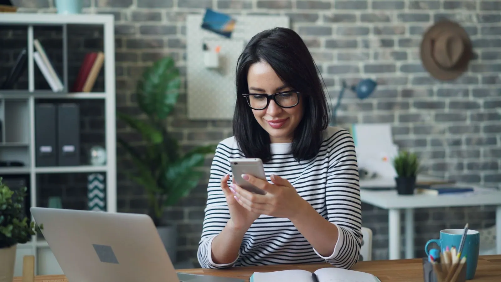 Office worker smiling while checking a phone notification