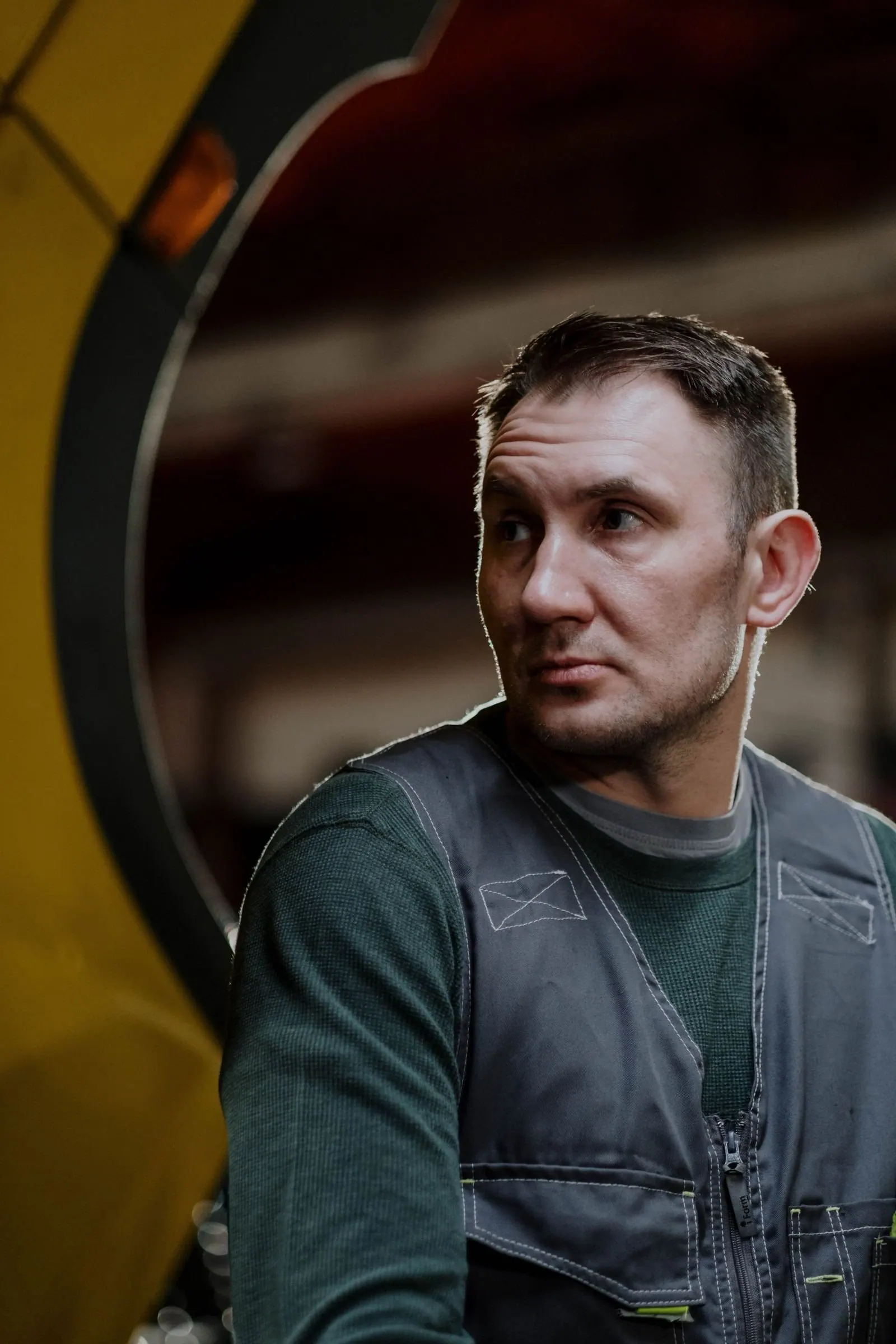 A worker in overalls beside the machine he runs