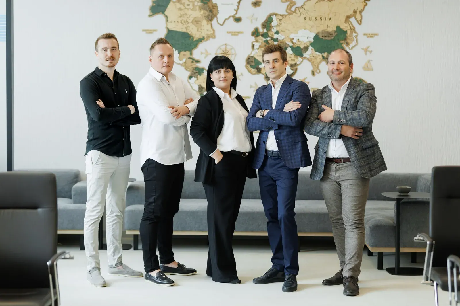 Alliance team members standing together in front of a world map in the office