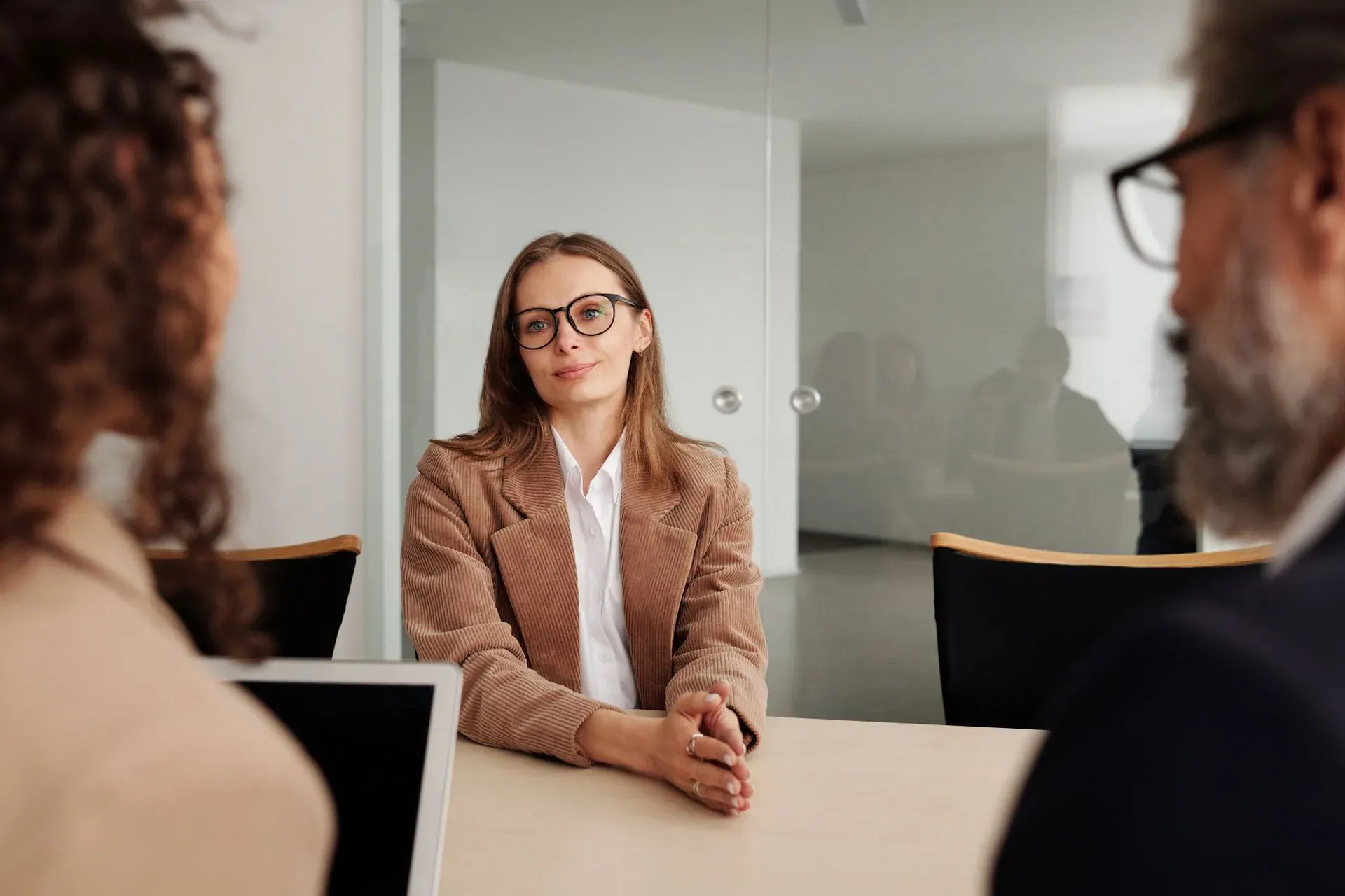 A jobseeker and a recruitment consultant talking across a table in a bright office
