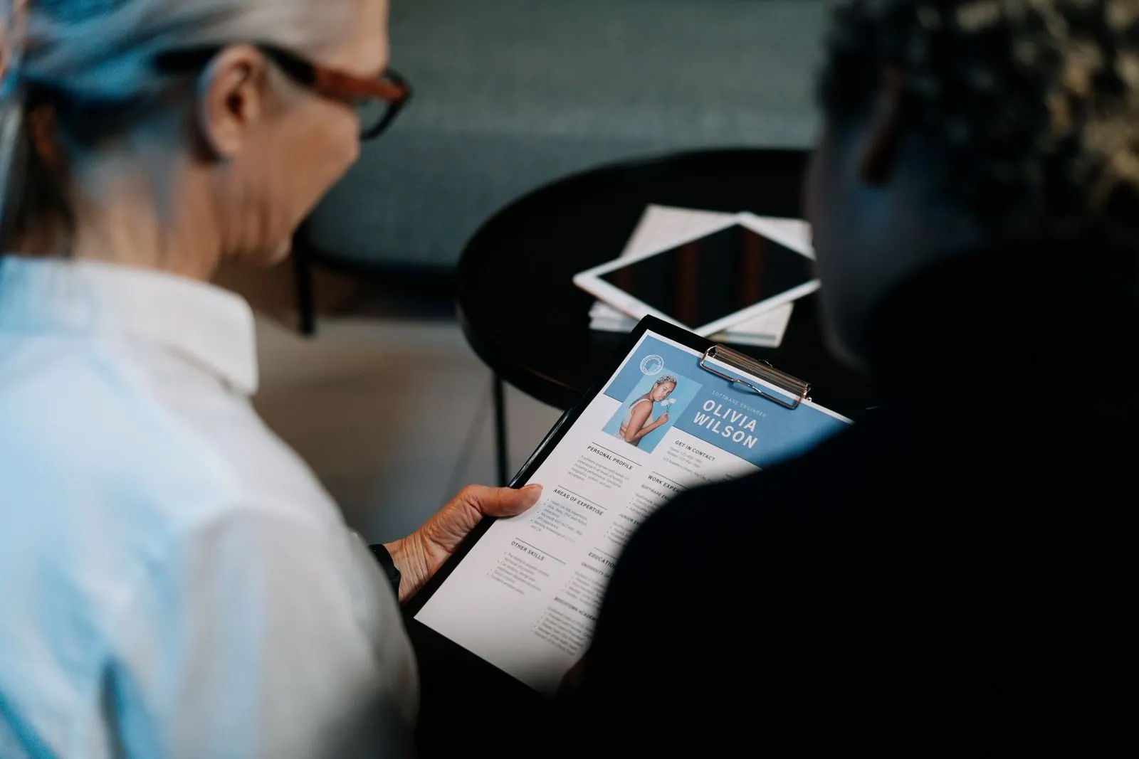 Recruiter reviewing a resume on a clipboard
