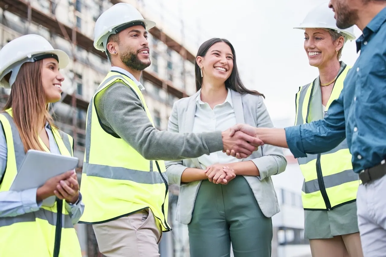 Construction professionals greeting a business representative on site, illustrating connections between people and employers